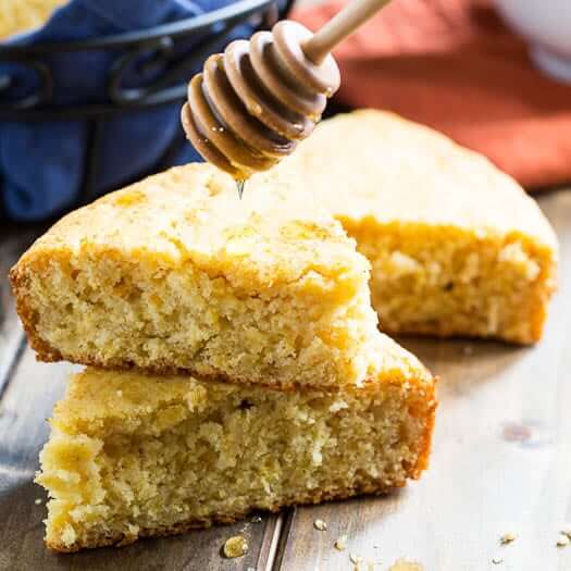 Honey cornbread with a honey dipper dripping honey onto it